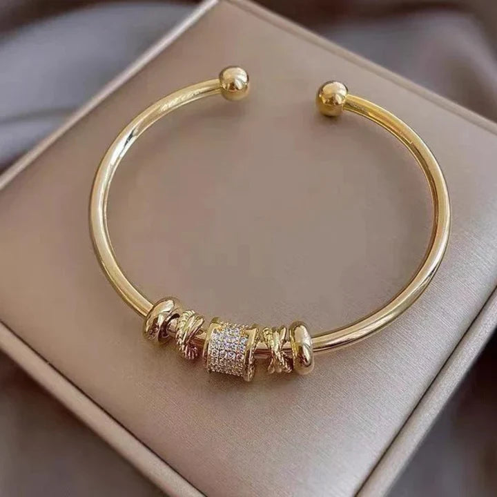 Justerbart armband i guldton med dekorativa detaljer